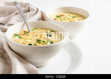 Deux bols de maïs crémeux et de courgette avec une cuillère à soupe dans un bol. Banque D'Images