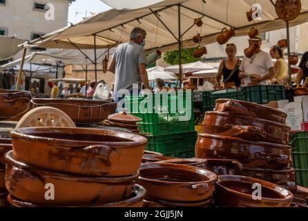 Gros plan des ustensiles de cuisine en céramique populaires de l'île de Majorque dans un marché de rue. À l'arrière-plan, les personnes qui vendent et achètent ne sont pas reconnaissables Banque D'Images