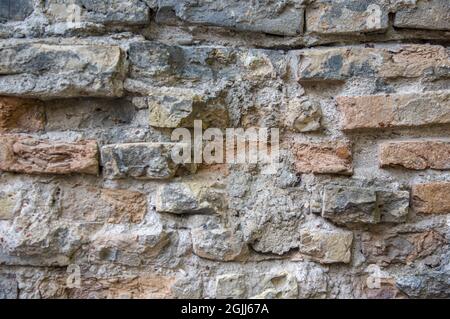 Gris blanc noir rouge orange vieux mur de briques vintage arrière-plan. Rustique cimenté mur de maison de brique texture avec la surface de grunge. Façade de bâtiment miteuse avec plâtre endommagé Banque D'Images