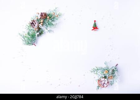 Branches d'épinette avec des cônes, un arbre de Noël miniature et perles sur fond blanc. Le nouveau-an de l'étapage. Copier l'espace pour le texte. Banque D'Images