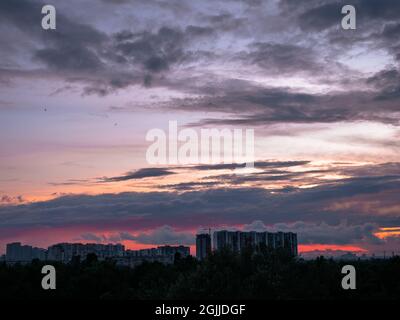Coucher de soleil coloré sur Kiev (Kiev) ville avec des bâtiments à l'horizon. Paysage urbain industriel sur fond de soleil couchant avec des paysages rouges et lilas. Banque D'Images