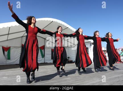 Hawiyya Dabke le groupe de danse palestinienne toute-femelle dansant sur Hastings Pier, événement culturel de la journée « Palestine sur le Pier », Hastings, Sussex, Royaume-Uni Banque D'Images