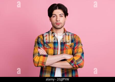 Photo de doux sérieux jeune gars habillé à carreaux vêtements bras pliés isolé couleur rose fond Banque D'Images