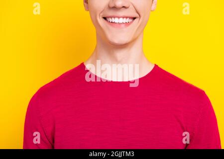 Photo de doux positif jeune gars cou habillé rouge pull-over sourire isolé couleur jaune fond Banque D'Images