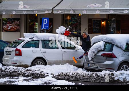 Homme déneigement du parking de Bucarest, Roumanie, 2021 Banque D'Images