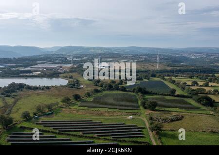 Vue aérienne de la centrale solaire sur un champ vert. Panneaux électriques pour la production d'énergie écologique propre. Banque D'Images