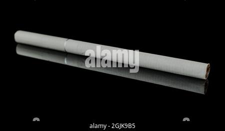 Une fine cigarette sur fond noir, avec réflexion Banque D'Images