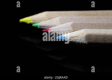 Crayons de couleur dans le noir sur fond noir Banque D'Images