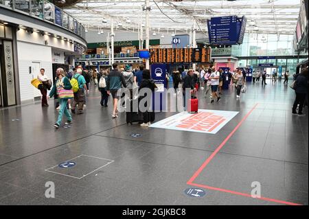 Les passagers de Manchester Piccadilly vérifient les cartes d'information. Banque D'Images