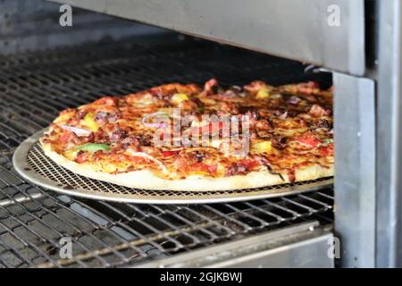 Une délicieuse pizza avec beaucoup de fromage et d'ingrédients cuits au four Banque D'Images