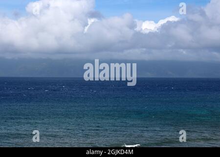 Plusieurs nuances d'eau bleue de l'océan Pacifique avec des cumulus couvrant Molokai au loin à Kaanapali Beach à Maui, Hawaii, États-Unis Banque D'Images