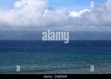 Plusieurs nuances d'eau bleue de l'océan Pacifique avec des cumulus couvrant Molokai au loin à Kaanapali Beach à Maui, Hawaii, États-Unis Banque D'Images