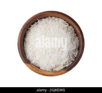 Flocons de noix de coco râpés dans un bol sur une table en bois. Banque D'Images