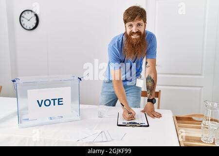 Un jeune homme de parti politique souriant, souriant, est content de travailler au collège électoral. Banque D'Images