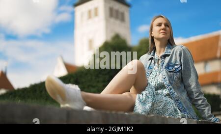 Femme se reposant contre l'église dans le vieux Tallinn. Banque D'Images