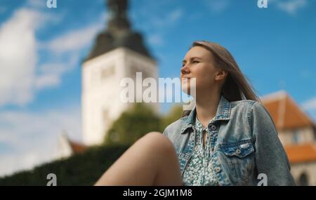 Femme se reposant contre l'église dans le vieux Tallinn. Banque D'Images