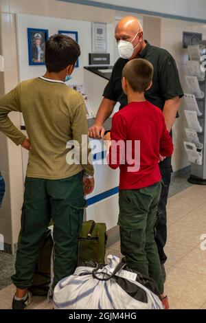 STATION NAVALE DE ROTA, Espagne (sept 9, 2021) les évacués de l'Afghanistan parlent à un employé du terminal aérien de la Naval Station (NAVSTA) Rota avant leur départ sur un vol charter américain vers les États-Unis, le 9 septembre 2021. NAVSTA Rota appuie la mission du ministère d'État visant à faciliter la réinstallation en toute sécurité des citoyens américains, des bénéficiaires de visas spéciaux d'immigration et des populations vulnérables d'Afghanistan. (É.-U. Photo du corps marin par le sergent d'état-major. Brytani Mudick) Banque D'Images