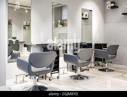 Salon de coiffure intérieur, magasin de beauté moderne après rénovation. Salon de coiffure intérieur vide avec miroirs et chaises en cuir. Salon de coiffure branché et propre avec Banque D'Images