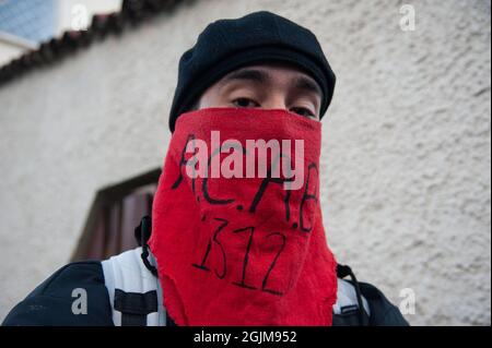 Bogota, Colombie. 10 septembre 2021. Un manifestant couvre son visage avec un foulard rouge qui lit l'acronyme 'A.C.A.B 1312' au poste de police de Villa Luz CAI ont été des policiers torturés Javier Ordoñez le 9 septembre 2020, plus tard le même jour plusieurs postes de police ont été vandalisés et brûlés en raison de la mort d'Ordoñez, et le nombre de morts de 12 autres personnes qui sont mortes de l'utilisation d'armes à feu par la police et de cas de brutalité la même nuit. Le 9 septembre 2021 à Bogota, Colombie. Crédit : long Visual Press/Alamy Live News Banque D'Images