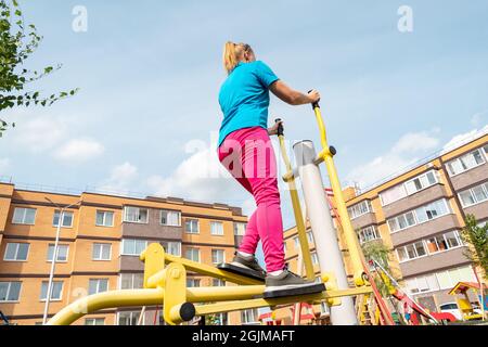 jeune femme s'entraîner sur la rue gym machine elliptique entraîneur de croix dans une cour de ville Banque D'Images