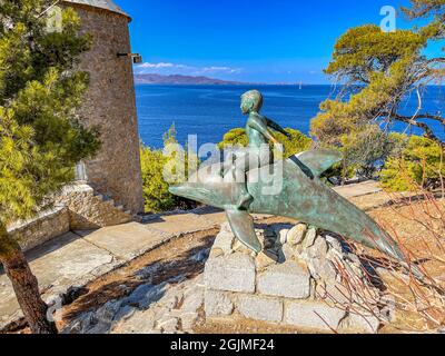 Belle statue d'un garçon en bronze sur un dauphin, une œuvre d'art basée sur le film du même nom, filmée ici en 1957, Hydra Island, Grèce Banque D'Images