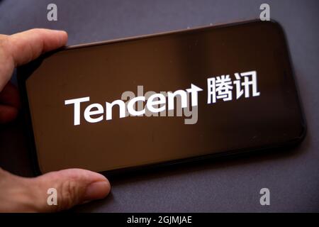 Tencent Holdings Ltd. Est une société chinoise de portefeuille de conglomérat technologique multinational.Un smartphone avec le logo Tencent dans la main. Banque D'Images