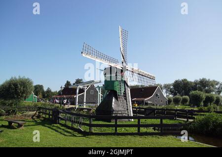 Touristes marchant sur un petit pont-levis et un petit moulin à vent dans le musée hollandais de Zaanse Schans. Zaanstad, pays-Bas, septembre Banque D'Images