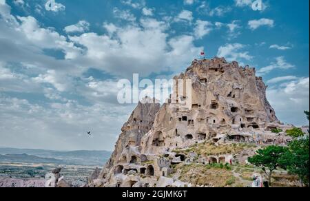 Formation naturelle de vestiges volcaniques en pierre et grotte faite de l'humain à l'intérieur du château de bord (uchisar) en cappadoce avec magnifique ciel fond Banque D'Images