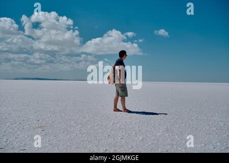 Un homme dans le lac salina ou le lac salé (Tuz golu) et ils regardent à l'horizon et le ciel bleu Banque D'Images