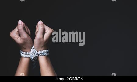 Femme main attachée avec la corde, représentant l'idée de la liberté de la presse ou de la liberté d'expression sur fond sombre en touche basse. International humain r Banque D'Images