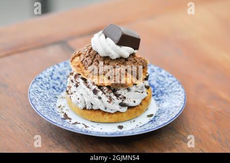 petit pain, pâte de choux avec garniture en poudre de chocolat ou eclair pour servir Banque D'Images