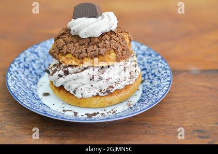 petit pain, pâte de choux avec garniture en poudre de chocolat ou eclair pour servir Banque D'Images