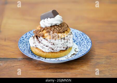 petit pain, pâte de choux avec garniture en poudre de chocolat ou eclair pour servir Banque D'Images