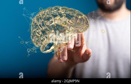 Photo d'une main atteignant le modèle 3D d'un concept de cerveau artificiel sur fond bleu Banque D'Images