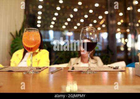 Verres avec apéritif et vin à table au restaurant Banque D'Images