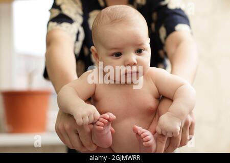 Le bébé fait de la gymnastique à la maison le matin Banque D'Images