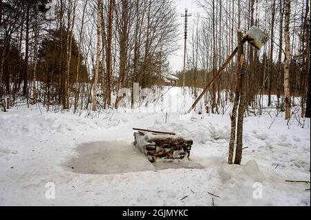 Bien en bois en hiver dans la forêt Banque D'Images