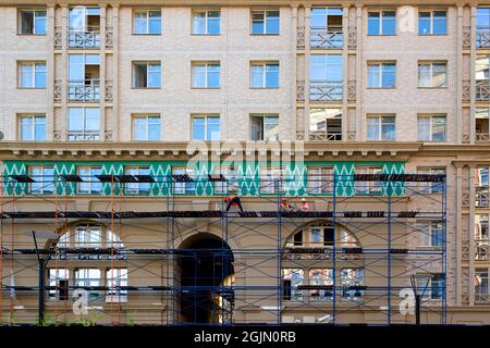 Saint-Pétersbourg, Russie - 09 juillet 2021 : des constructeurs effectuent des travaux de façade sur un nouveau bâtiment résidentiel de plusieurs étages à Saint-Pétersbourg Banque D'Images