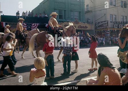 Las Vegas 1959. Une parade passe par le centre-ville de Las Vegas et Fremont Street et les gens sont debout sur les trottoirs. Au premier plan, un groupe d'enfants tous vêtus de tenues de cow-boy applaudit les cavaliers qui passent dans la rue. Original KODACHROME. Crédit Roland Palm réf. 6-2-10 Banque D'Images