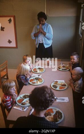 États-Unis Alabama 1966. Une garderie en Alabama où travaille une femme afro-américaine. Elle dit une prière avant d'avoir un repas avec les enfants qui sont blancs. Crédit Roland Palm réf. 6-6-7 Banque D'Images