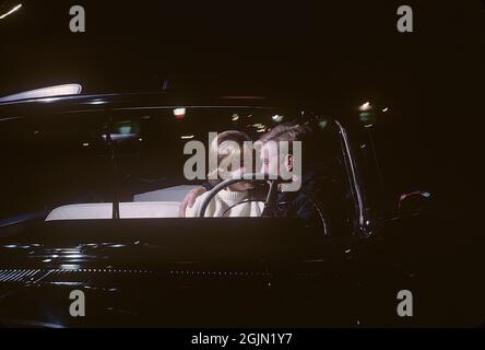 États-Unis dans les années 1960. Un jeune couple dans un cabriolet la nuit. Ils sont assis près les uns des autres sur le siège avant de la voiture. Original KODACHROME. Crédit Roland Palm réf. 6-9-16 Banque D'Images