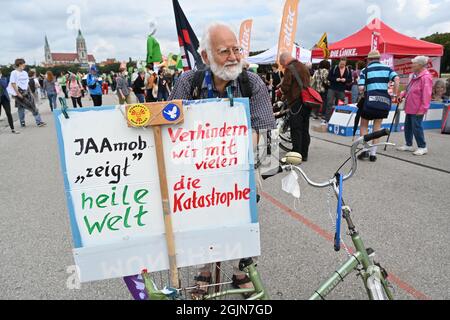 13 mars 2020, Bavière, Munich: Günter Wimmer de Munich se trouve à côté de son vélo pliant, sur lequel il a joint une affiche avec l'inscription ' IAAmob montre heile Welt, verhindern wir mit vielen die Katastrophe'. Sous la devise '#getout', une démonstration et un rallye à vélo contre l'International Motor Show (IAA) auront lieu. La police attend jusqu'à 35,000 participants pour le rallye à vélo et jusqu'à 10,000 participants pour la manifestation. Photo: Felix Kästle/dpa Banque D'Images