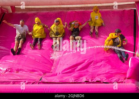 Baiter Park, Poole, Dorset, Royaume-Uni.11th septembre 2021.Course for Life Poole Pretty Muddy est revenu après avoir été annulé l'année dernière en raison de Covid-19, avec des centaines de personnes vêtues de rose, se joignant à la lutte contre le cancer et de recueillir de l'argent pour cancer Research UK, négociant des obstacles tout au long du parcours 5km et s'amuser à se couvrir dans la boue.S'amuser sur le toboggan gonflable.La famille Duck Nuggets s'amuse bien !Crédit : Carolyn Jenkins/Alay Live News Banque D'Images