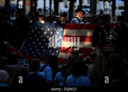 New York, États-Unis. 11 septembre 2021. Des membres de la police et des pompiers de New York ont un drapeau pour l'hymne national au Mémorial du 9/11 septembre qui a lieu à l'occasion du 20e anniversaire des attentats du 11 septembre à Manhattan, New York, le samedi 11 septembre 2021. Pool photo par Chip Somodevilla/UPI crédit: UPI/Alay Live News Banque D'Images