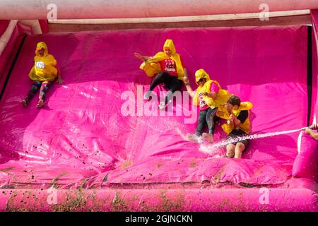 Baiter Park, Poole, Dorset, Royaume-Uni.11th septembre 2021.Course for Life Poole Pretty Muddy est revenu après avoir été annulé l'année dernière en raison de Covid-19, avec des centaines de personnes vêtues de rose, se joignant à la lutte contre le cancer et de recueillir de l'argent pour cancer Research UK, négociant des obstacles tout au long du parcours 5km et s'amuser à se couvrir dans la boue.S'amuser sur le toboggan gonflable.La famille des canards Nuggets Amuse-toi bien.Crédit : Carolyn Jenkins/Alay Live News Banque D'Images