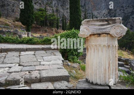 Fragment de colonne d'ordre ionique sculpté en marbre antique dans le Temple d'Apollon au site archéologique sacré de Delphes à Phosis, en Grèce. Banque D'Images