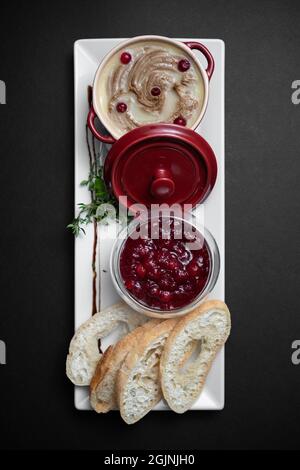 vue de dessus de pâté de foie de viande d'oie avec canneberge et pain sur fond noir Banque D'Images