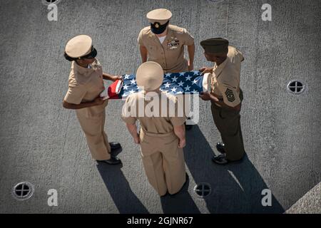 Détroit de Malacca, Malaisie. 11 septembre 2021. La Marine américaine et les Marines arborent un drapeau américain lors d'un souvenir du 20e anniversaire des attaques terroristes de 9/11 à bord de l'USS Portland le 11 septembre 2021 en cours dans le détroit de Malacca, en Malaisie. L'événement commémore les près de 3,000 personnes tuées par des terroristes le 11 septembre 2001. Crédit : Sgt. Alexis Flores/États-Unis Marines/Alamy Live News Banque D'Images