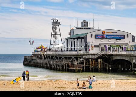 Bournemouth, Dorset, Angleterre - juin 2021 : jetée et plage à Bournemouth. Deux personnes sont sur le câble à glissière pour aller à la plage. Banque D'Images