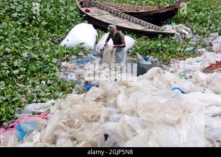 Non exclusif: DHAKA CITY, BANGLADESH - 10 SEPTEMBRE 2021: Un homme collecte le polythène et de traitement à l'intérieur de la route dans le fleuve Buriganga.travailleurs de Kamran Banque D'Images